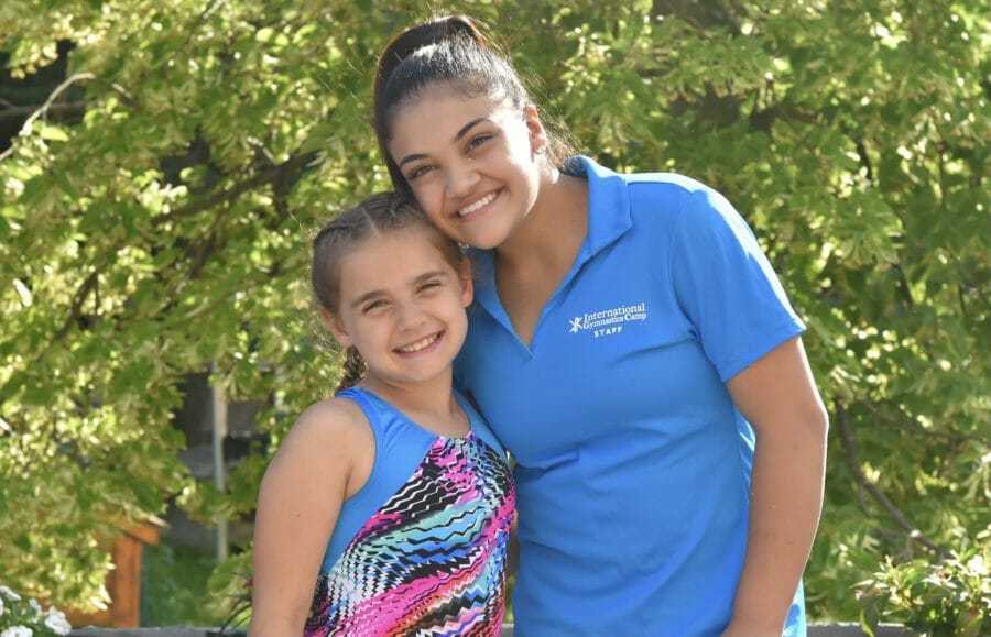 Celebrity gymnast with young girl, smiling