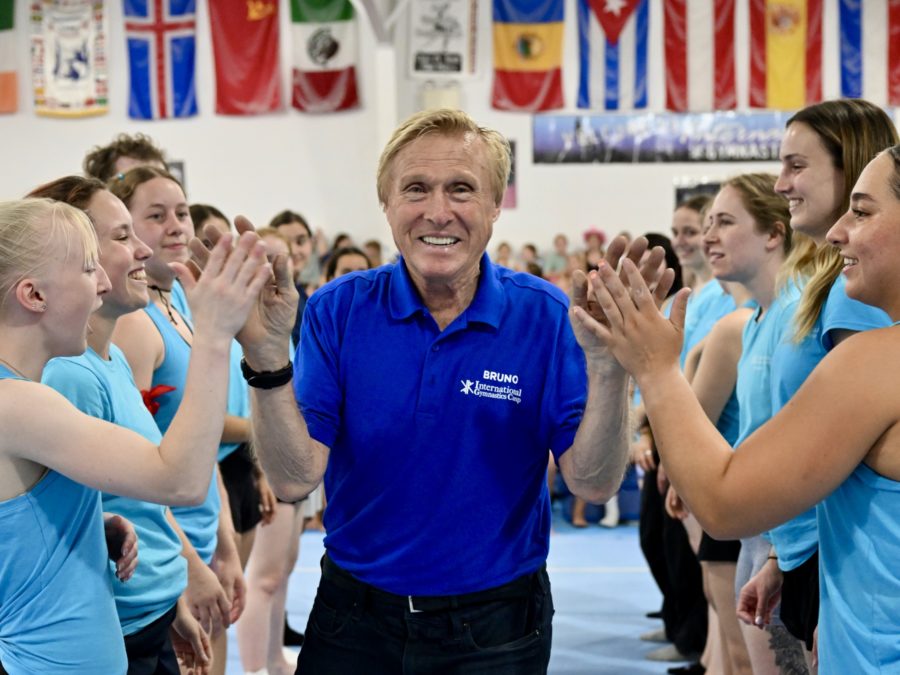 Bruno Klaus surrounded by people clapping and cheering as he smiles.