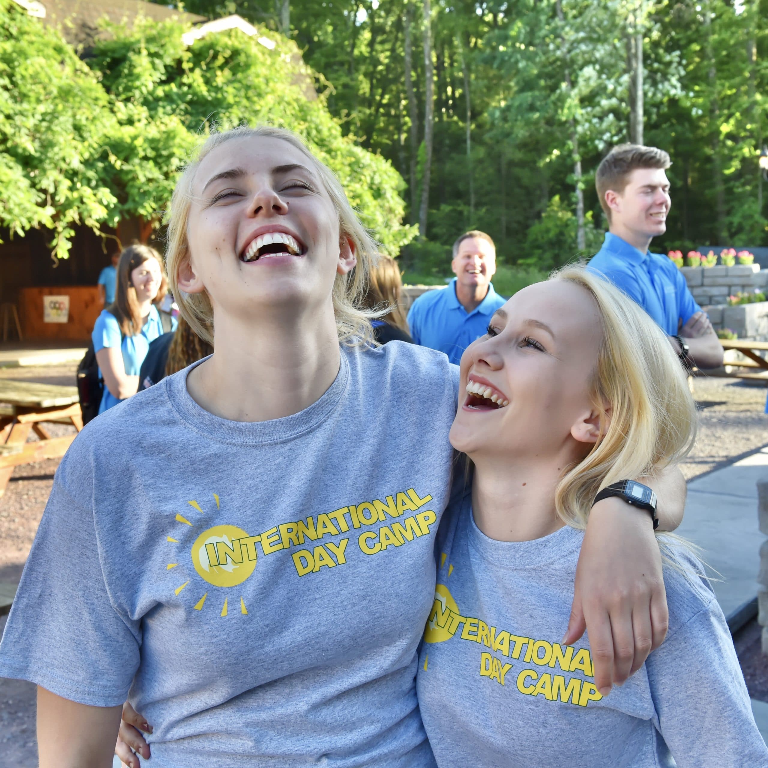 Two female staff members laughing outdoors
