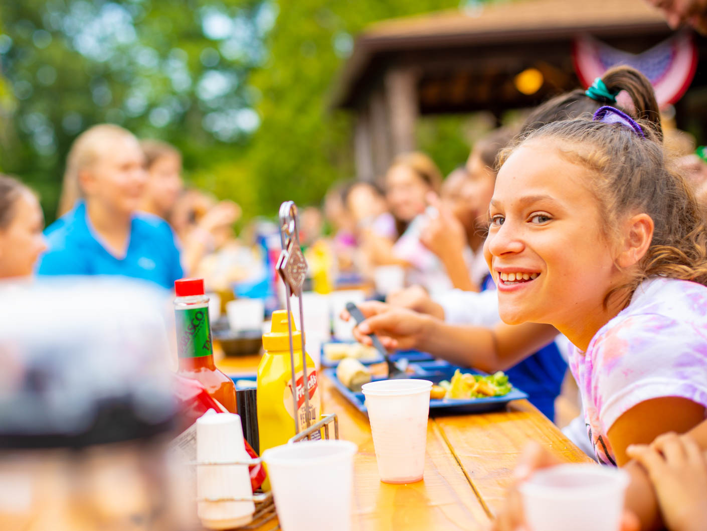 camper smiling at the long picnic tables