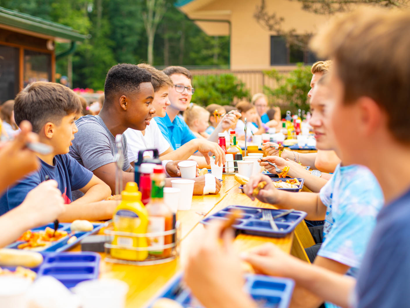 campers eating outside at long picnic tables