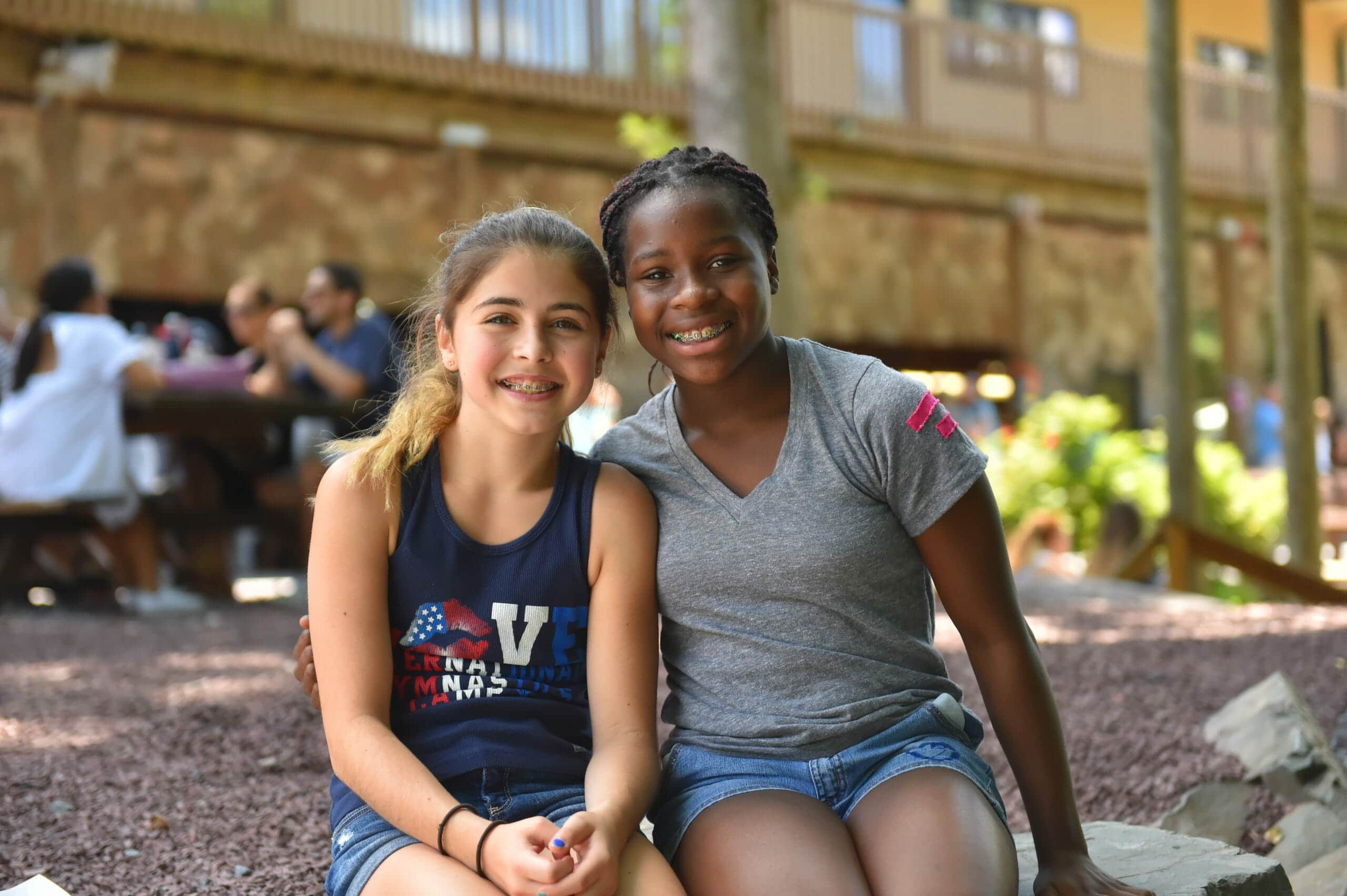 two young female gymnasts smiling at camp
