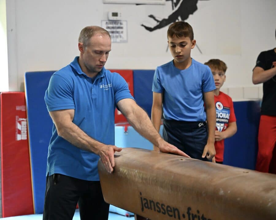 An IGC staff member coaches a young camper on how to do a move.