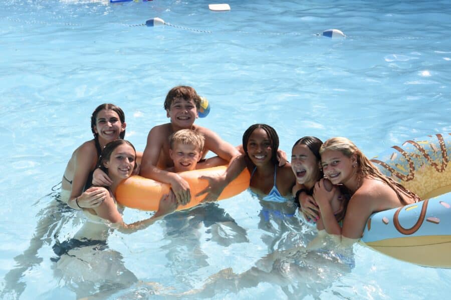 campers playing in the pool with pool floats.