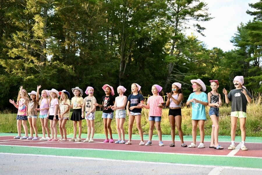 campers on an outside track, standing in a line for a game.