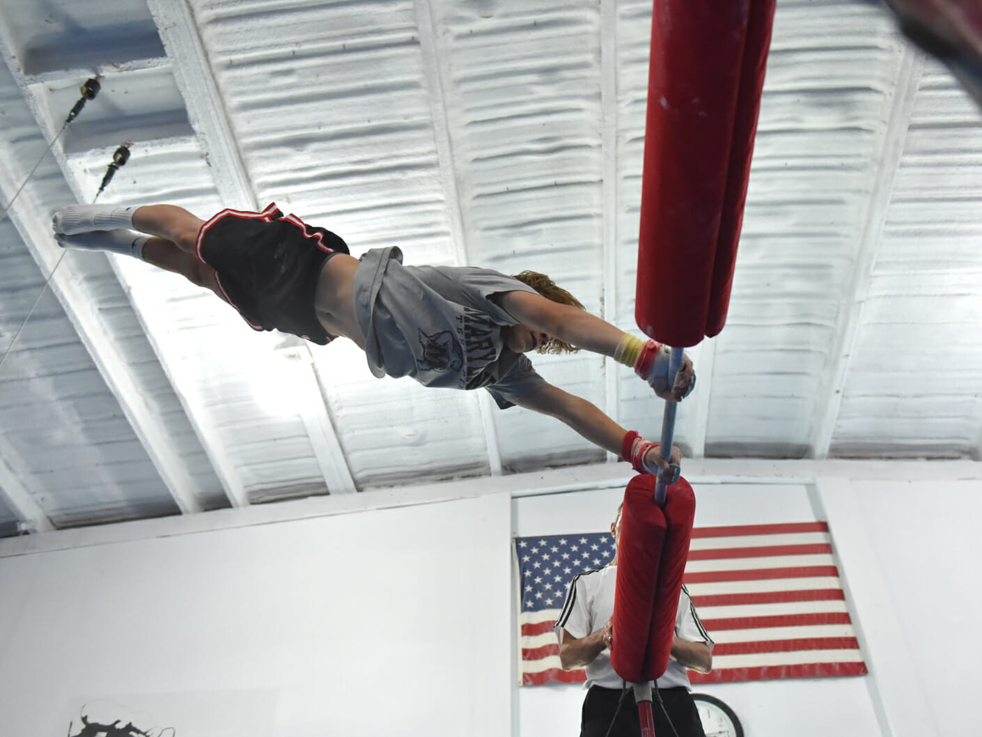 camper being instructed on the high bar